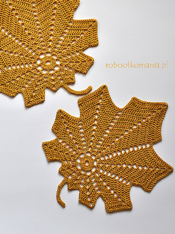 Two crocheted leaf placemats on a white surface.