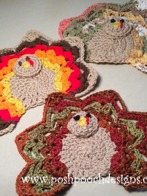 Three crocheted turkey dishcloths on a table.