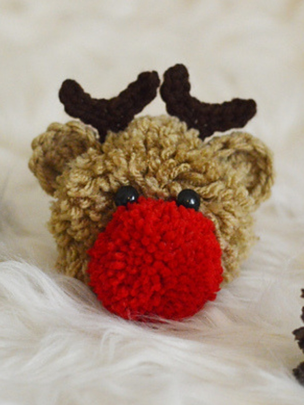 A crocheted reindeer with a red nose.