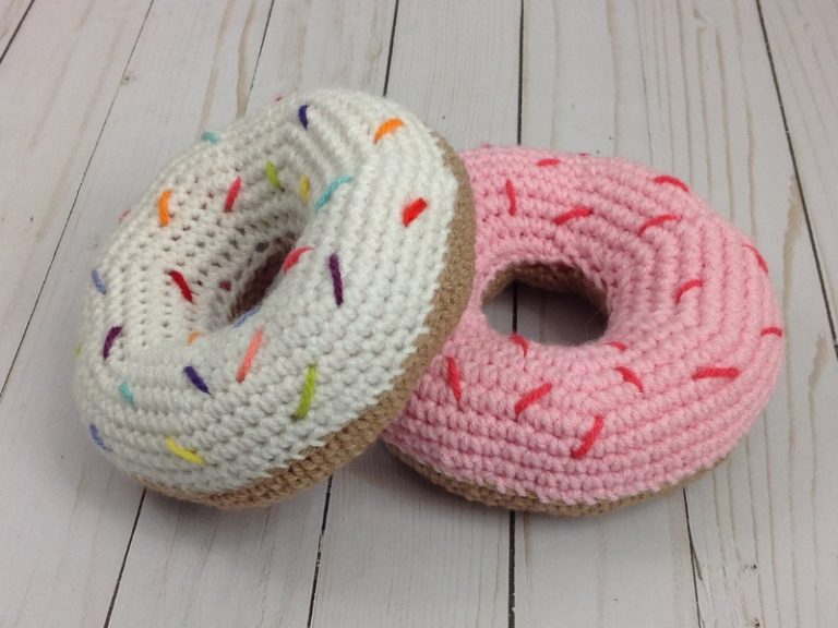 Two crocheted donuts with sprinkles on them.