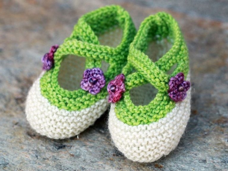 A pair of green and purple knitted baby shoes.