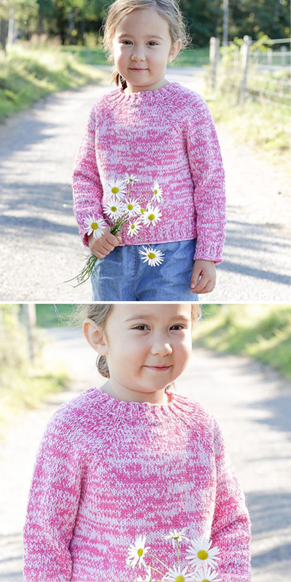 A young girl in a children's sweater smiling and holding daisies on a sunny path.