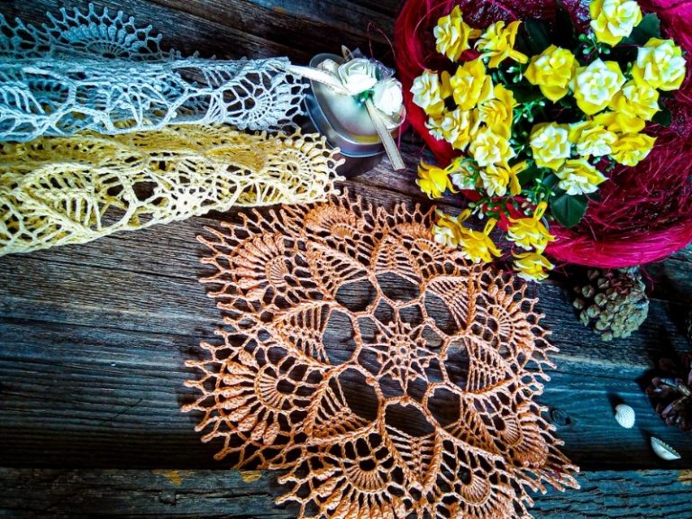 A free crochet doily on a wooden table.