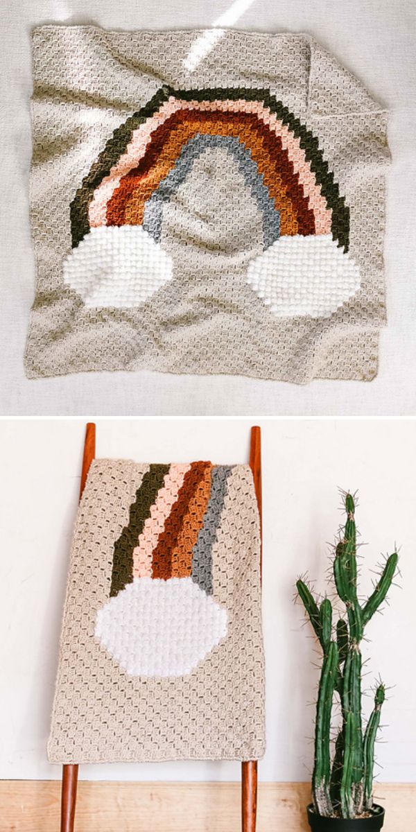A crocheted beige blanket with a rainbow pattern in muted tones and two white clouds, made using c2c crochet blankets patterns, shown laid flat and draped over a chair beside a tall cactus.