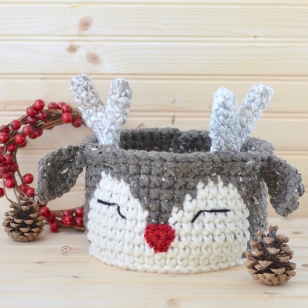 A crocheted reindeer basket on a wooden table.