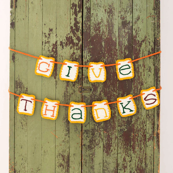 A wooden door with a banner that says give thanks.