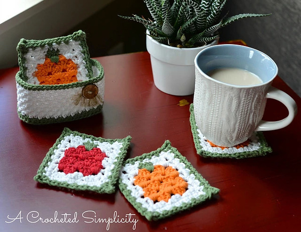 A crocheted pumpkin coaster and a cup of coffee on a table.