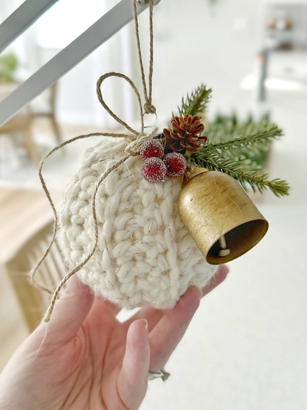 A person holding a crocheted christmas ornament.