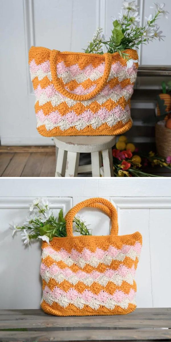 Two handcrafted orange and white tote bags displayed on a wooden stool with fresh flowers tucked inside each one.