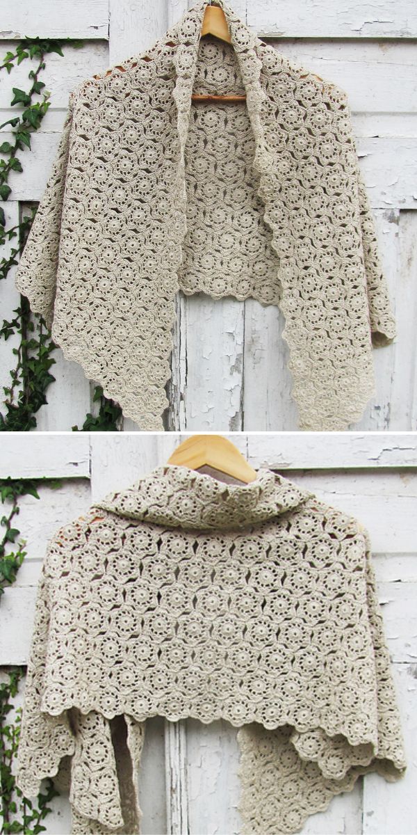 Beige crochet shawl hung on a white wooden surface.