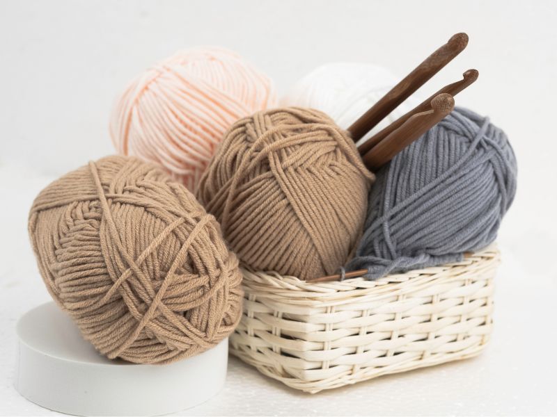 a basket with yarn and crochet hooks