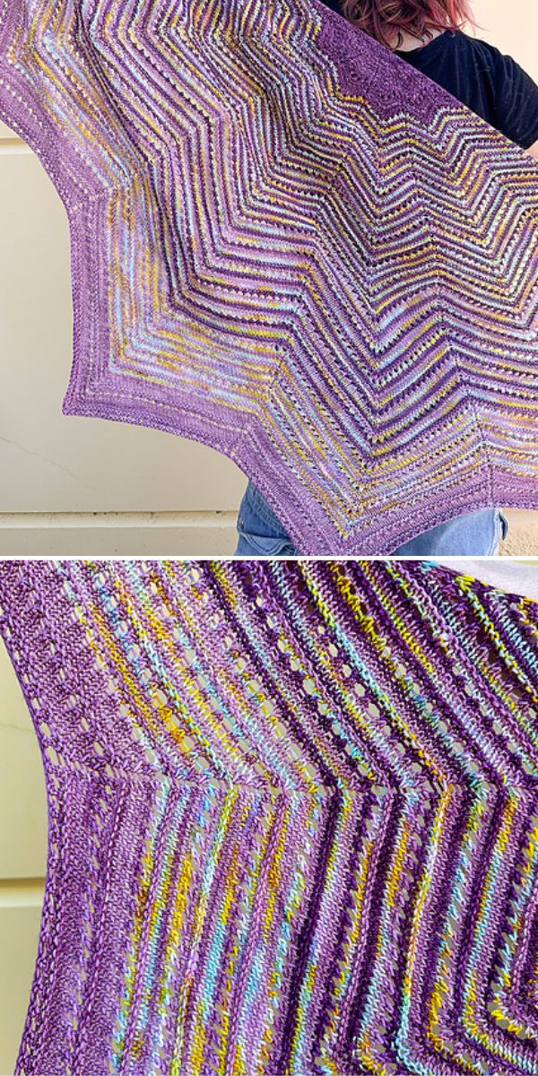 A person holds up a large, colorful knitted shawl with a zigzag pattern.