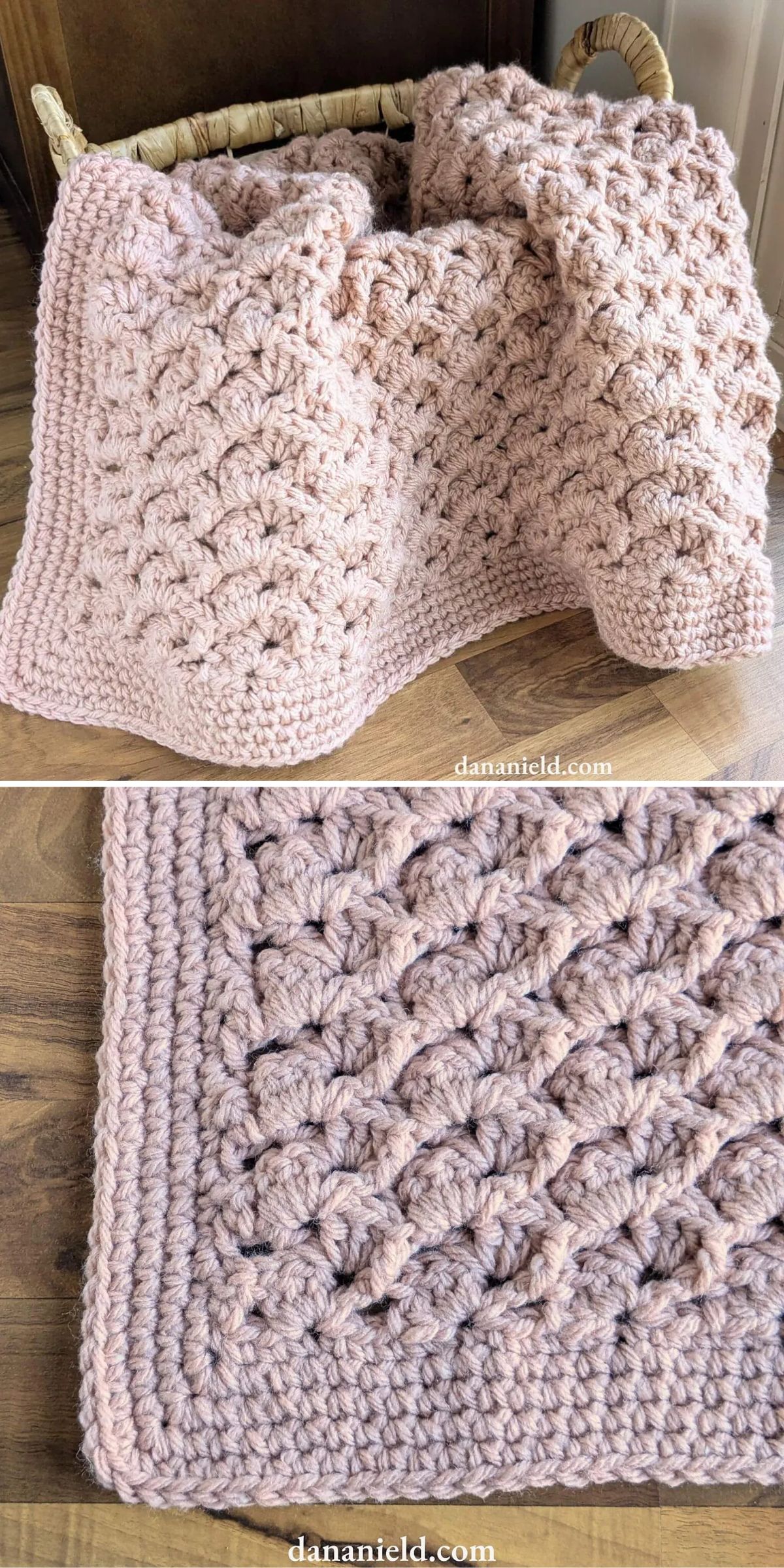 A chunky pink crocheted blanket with a textured, scalloped pattern draped over a wicker basket and shown close-up on a wooden floor.