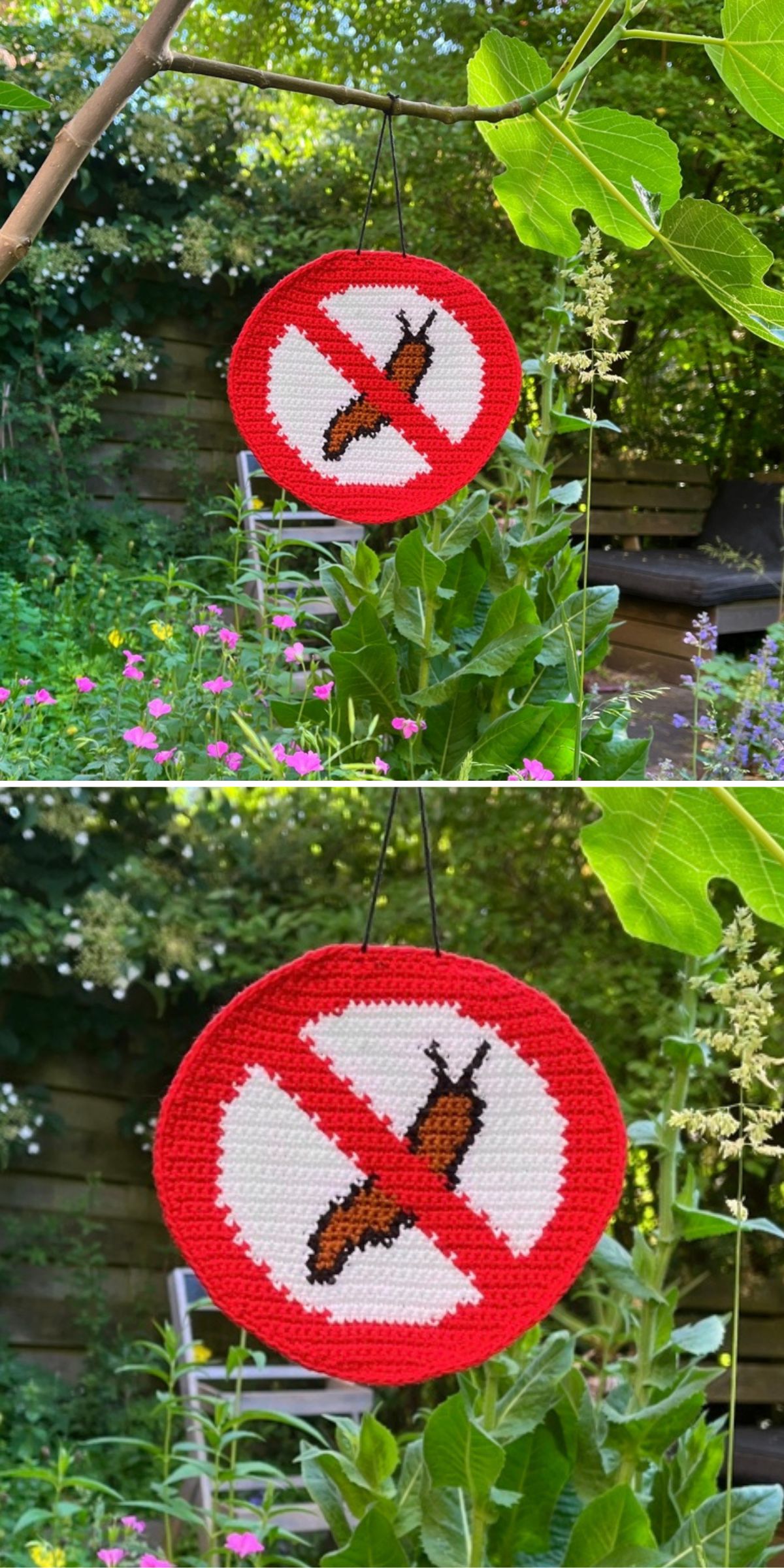 A crocheted sign with a red border and a slug inside a prohibition symbol hangs in a garden among green plants and flowers.