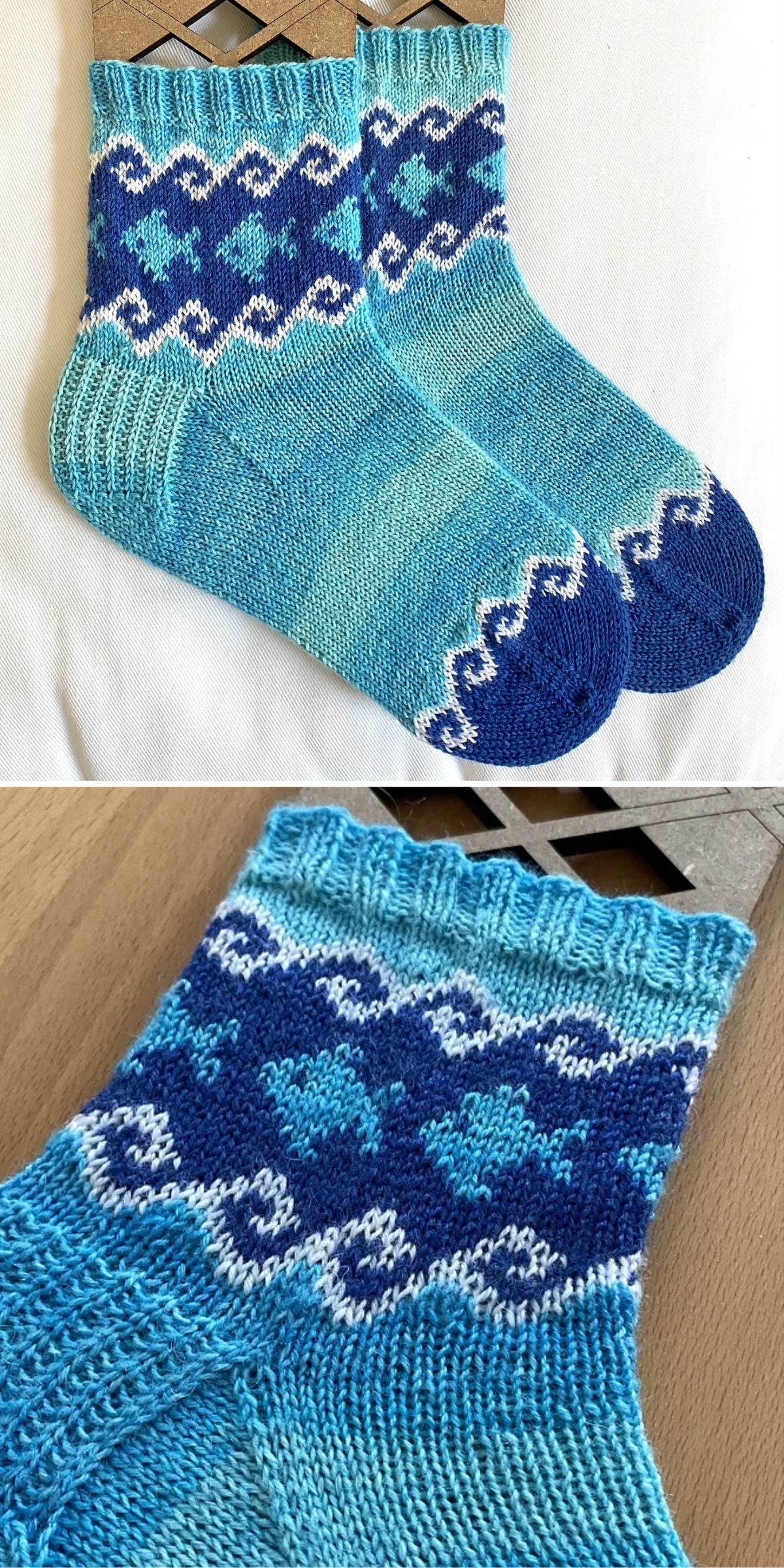 Two knitted socks in shades of blue with white and navy geometric patterns on the cuff, toe, and heel, displayed on a flat surface.