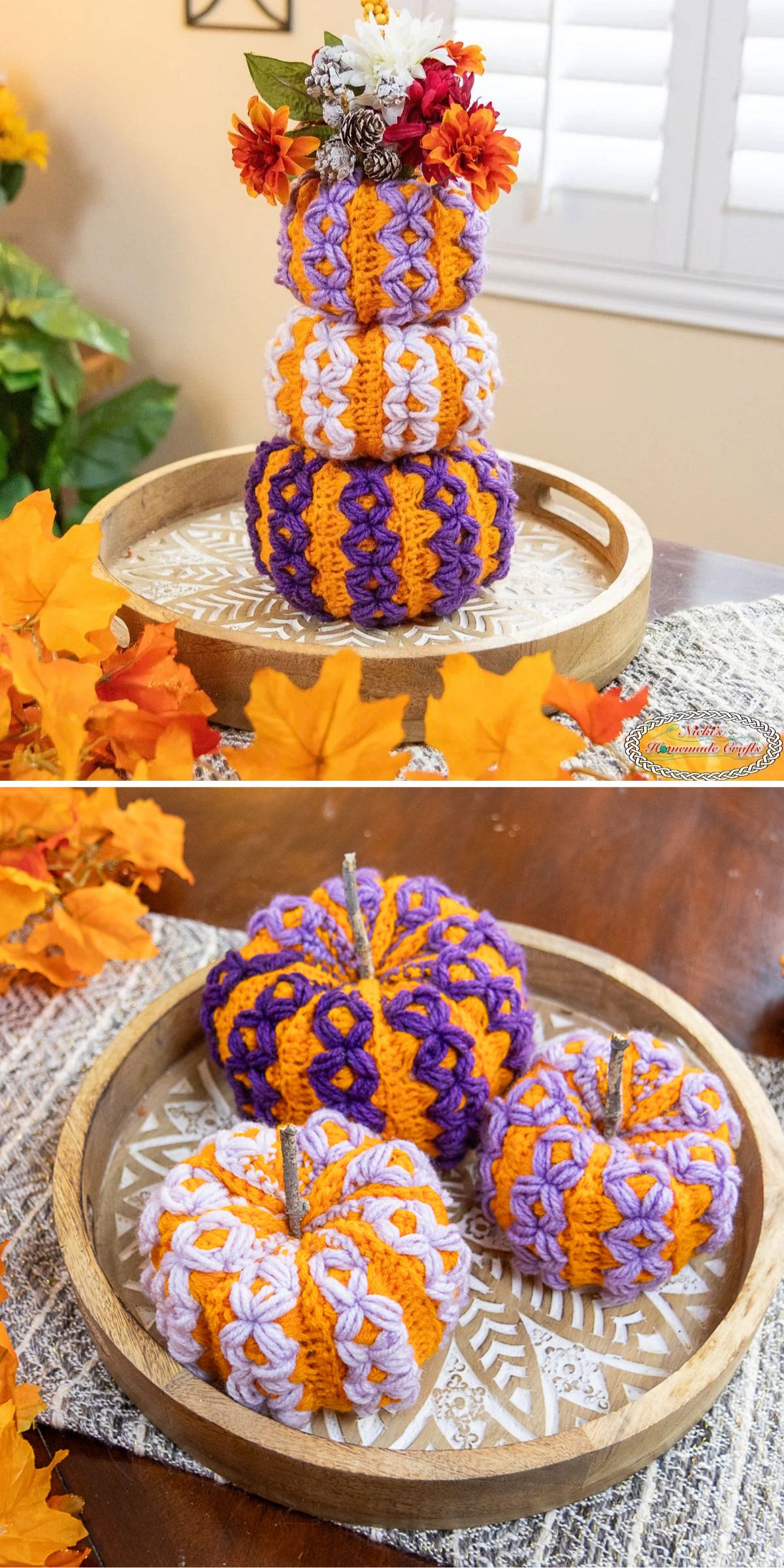Crocheted pumpkins in purple, orange, and white are arranged on a wooden tray, accented with artificial flowers and autumn leaves on a table.